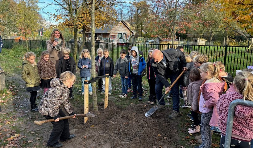 Wethouder Jan Kramer plant met kinderen van bassischool De Bongerd een Amerikaanse linde.